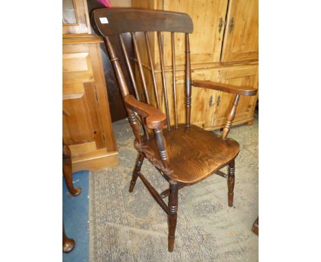 A solid Elm seated and other woods Kitchen elbow Chair having stick-back details and turned legs with "H" stretcher