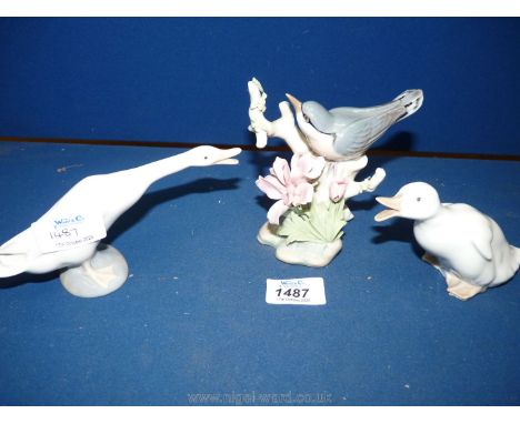 A Lladro figure of a goose, a Nao figure of a duckling and a Lladro figure of a bird standing on a branch.