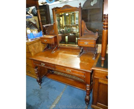 An Edwardian Mahogany dressing Table standing on turned legs united by a lower shelf and having two frieze drawers and bevell