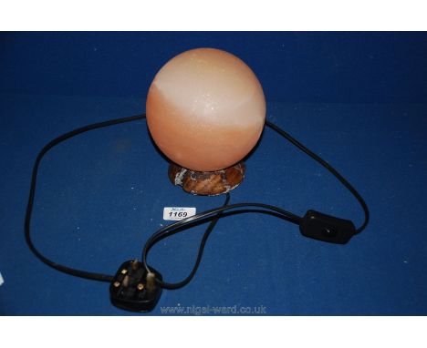 A Himalayan salt lamp, on wooden base, 7'' tall