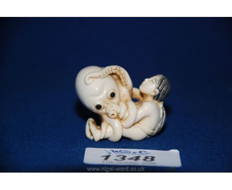 A good late Meiji ivory Netsuke depicting Ama and Tako, the girl pearl diver and the octopus, shown in erotic pose and signed