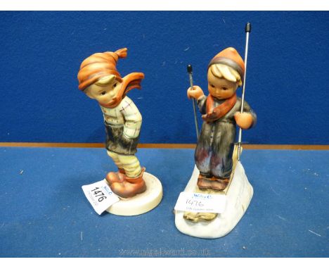 A Hummel figure of a Boy on skis and a young Boy standing in the wind.