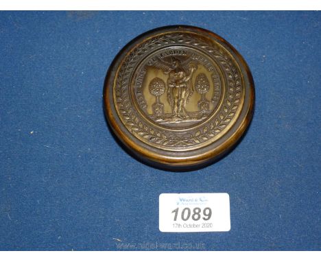 A horn circular snuff box, the central design within a laurel wreath and the figure of Flora, flanked by fruit trees in urns 