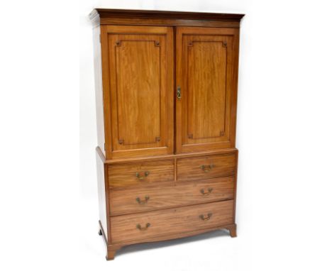 An Edwardian mahogany linen press with pair of panelled doors enclosing four slides above two short and two long drawers, to 