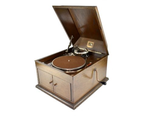 An HMV Model 103 hand-cranked gramophone with a number 4 sound box in oak case, with double door record cabinet to the front,