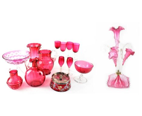 A Victorian cranberry glass epergne with central flared trumpet-form vase, flanked by three smaller vases and clear twisted g