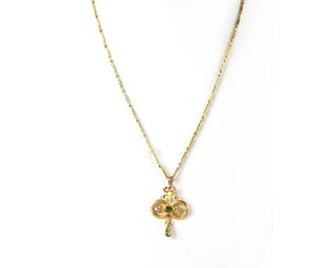 A 9ct gold pendant necklace in the form of a peridot in a circular mount with foliate detail, peridot drop beneath and bow ab