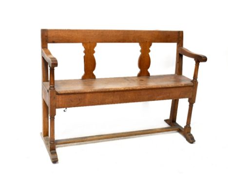 A 19th century oak bench with vase splats and open arms, on turned legs and stretchered supports, height 83cm, width 117cm.