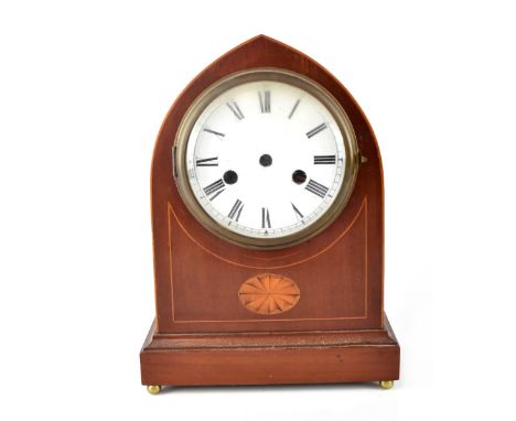 An Edwardian inlaid mahogany mantel clock, the arched case enclosing a twin-barrel movement striking on a coil, the silvered 