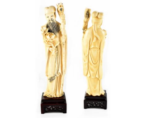 An early 20th century Chinese ivory figure of a religious travelling gentleman carrying a staff with dragon's head, scroll an