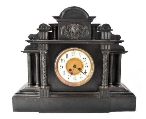 A 19th century mausoleum slate mantel clock, temple top with raised figural Classical head decoration above a gilded and enam
