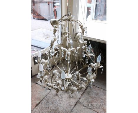 A contemporary vintage style chandelier light fitting, distressed cream metal in the form of leafy branches supporting eight 