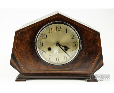 An Art Deco mantel clock, burr walnut with boxwood stringing, ebony flashes to base, the round silvered dial with Arabic nume