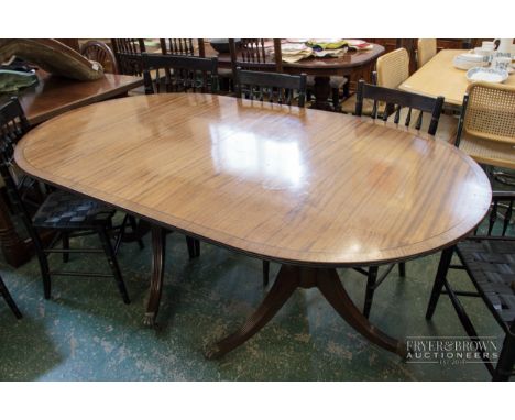 A reproduction dining table on two tripod pedestal supports, with extra leaf, brass lion paw caps and castors, without leaf 1