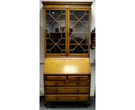 A Victorian oak secretaire bookcase, oversailing ogee cornice, two astral glazed doors enclosing three shelves, fall front do