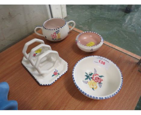 FOUR PIECES OF POOLE POTTERY INCLUDING A TOAST RACK.