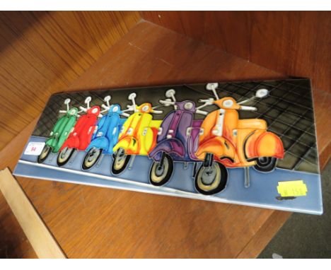 GLAZED CERAMIC WALL HANGING TILE DEPICTING MOPEDS.