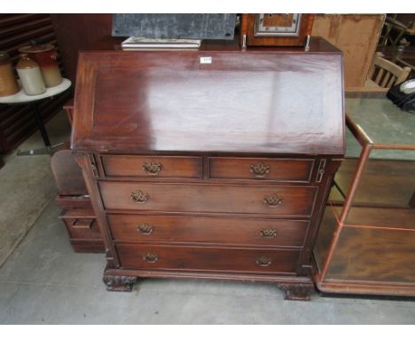 A Georgian style mahogany bureau, the fitted interior over five drawers and carved bracket feet