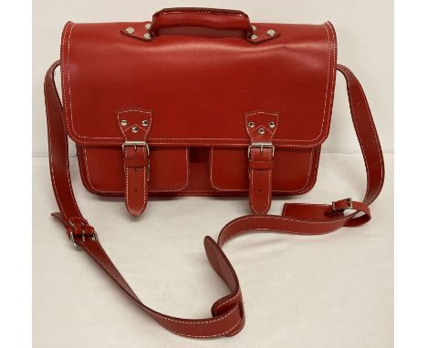 A large red leather satchel with white stitching and detachable name and address label.  Possibly The Cambridge Satchel Compa