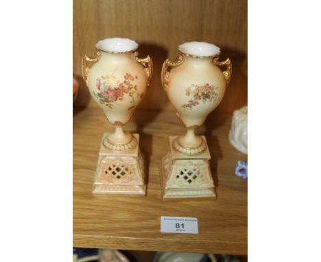 A PAIR OF ROYAL WORCESTER BLUSH IVORY SMALL TWIN HANDLED URNS ON PLINTHS 