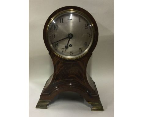 A large mahogany inlaid mantle clock on shaped base. Est. £50 - £80.
