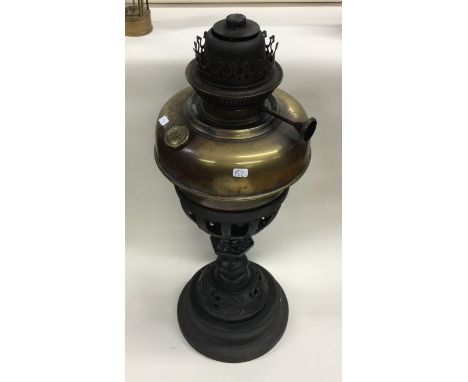An old cast iron and brass lamp. Est. £20 - £30.