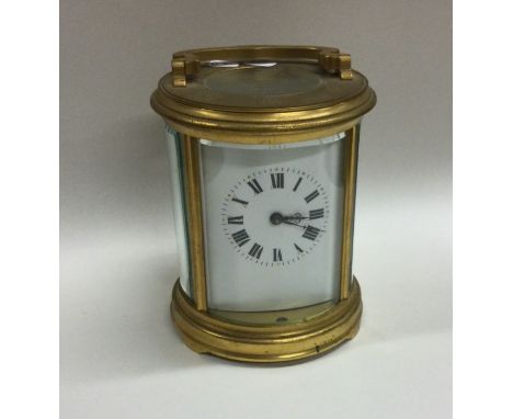 A circular brass carriage clock with chiming movement to white enamelled dial. Est. £100 - £150.