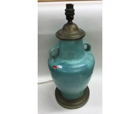 A large stylish pottery lamp with lug handles to pedestal foot. Est. £30 - £50.