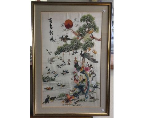 A framed and glazed tapestry of Chinese design decorated in bright colours. Est. £20 - £30.