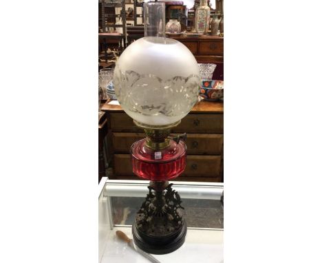 A good cranberry glass oil lamp with cast iron reservoir. Est. £30 - £50.