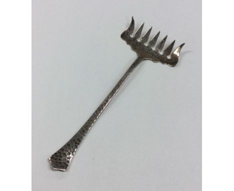 A silver sardine fork of textured form. Marked Sterling. Approx. 13 grams. Est. £20 - £30.