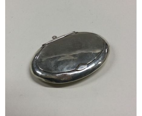 A small oval silver hinged top compact. Est. £20 - £30.
