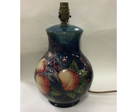 MOORCROFT: A 'Blue Finches' pattern table lamp decorated with flowers. Est. £100 - £150.