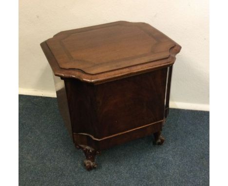A hinged top commode on scroll feet. Est. £10 - £20.