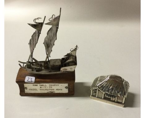 A novelty silver model of a building together with a silver junk. Approx. 73 grams. Est. £20 - £30.