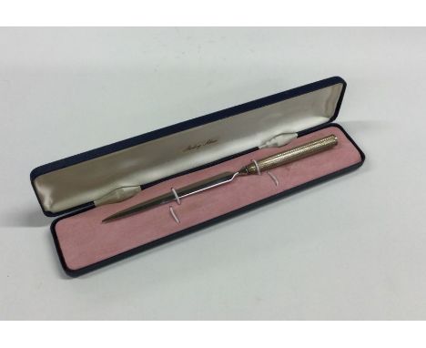 A cased silver engine turned letter opener. Approx. 21 grams. Est. £15 - £20.