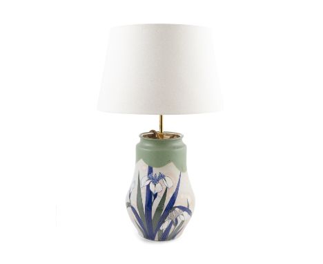 A polychrome Liberty style pottery baluster vase, adapted as a table lamp, the off-white ground decorated with lilies in the 