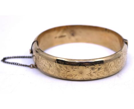 9ct Gold Hinged Bangle with Safety Chain. The Bangle is hallmarked "9 375" for 9ct Gold.  The Bangle has floral decoration on