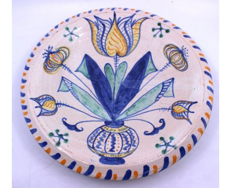 English Delftware blue dash tulip charger.  Decorated in polychrome with stylized tulips, leaves and other flowers in a vase 