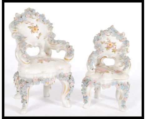 A pair of 19th Century Victorian miniature ceramic Louis XVII style chairs having floral encrusted floral decoration, blue cr