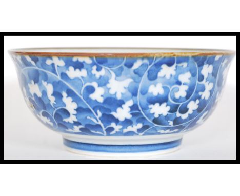 An early 20th Century Chinese blue and white ceramic bowl having hand painted decoration depicting flowers and scrolls. 8cm h