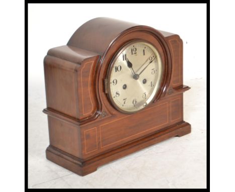 An early 20th Edwardian mahogany inlaid mantel clock having a domed top with inlaid satin wood inlaid decoration having a rou