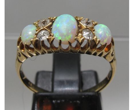 18ct gold three stone opal ring. The oval opals separated by diamond points. Ring size O&1/2. Approx weight 3.5 grams. (B.P. 