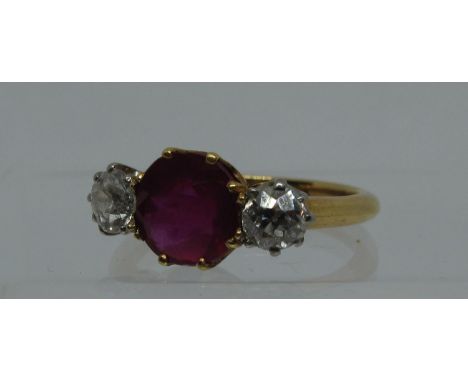 A synthetic ruby and diamond three stone ring. Ring size L & 1/2. Approx weight 3.8 grams. (B.P. 21% + VAT)Condition is good 