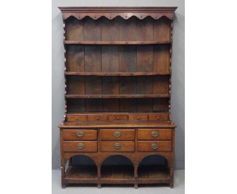 19th Century oak two stage rack back pot board dresser, the moulded cornice above carved frieze with boarded rack, fitted she