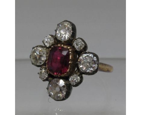 Victorian ruby and diamond ring. The ruby set in silver and surrounded by old cut diamonds on a later 14ct gold band. Ring si