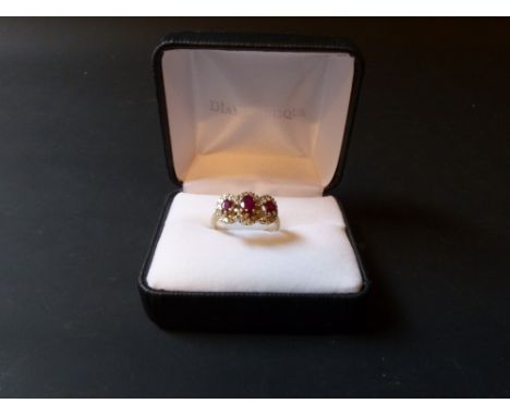 A 9ct gold ruby and diamond three stone cluster ring.