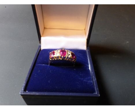 An 18ct gold three stone ruby and diamond set dress ring.