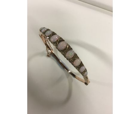 A circa 1920's opal set stiff bracelet with diamond points.