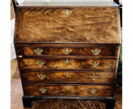 A George III mahogany bureau, circa 1780, fall front enclosing fitted interior with an arched central panelled door, over a d